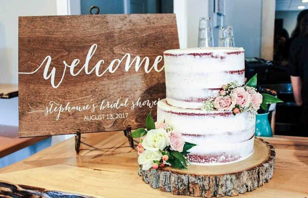 wooden welcome sign next to a cake