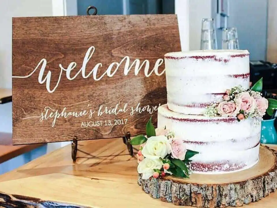 wooden welcome sign next to a cake