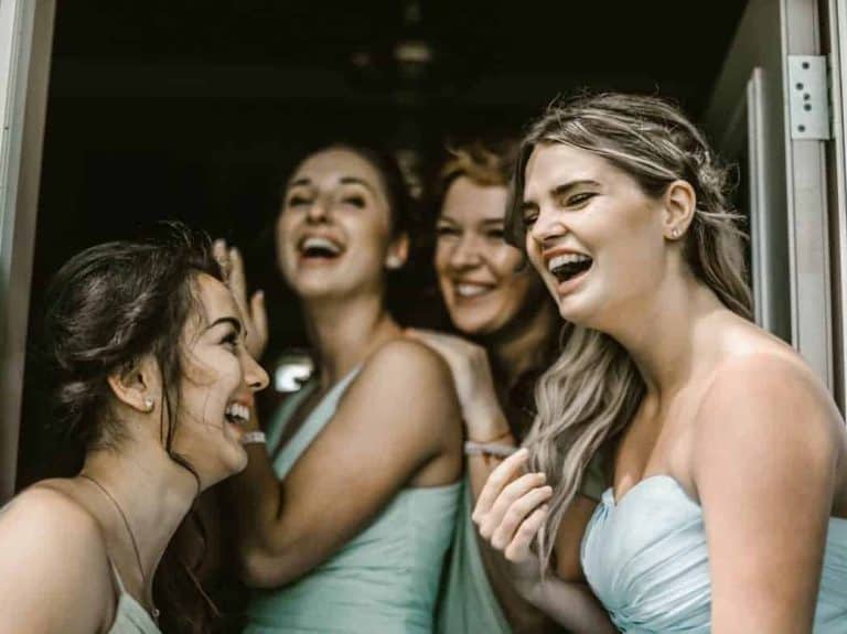 four bridesmaids laughing together