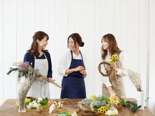 3 women arranging flowers at a venue for a fall bridal shower