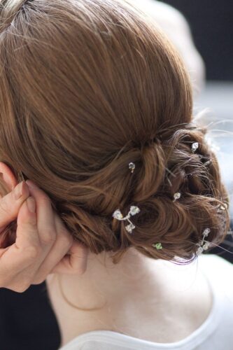 a low bun with twists woven in and adorned with small floral pins