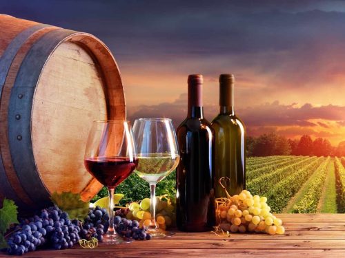 Bottles And Wineglasses With Grapes At Sunset