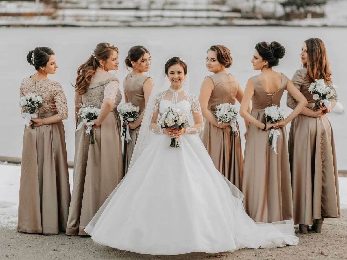 Bridesmaid Pose Ideas with bride at center and bridesmaids looking back over the shoulder
